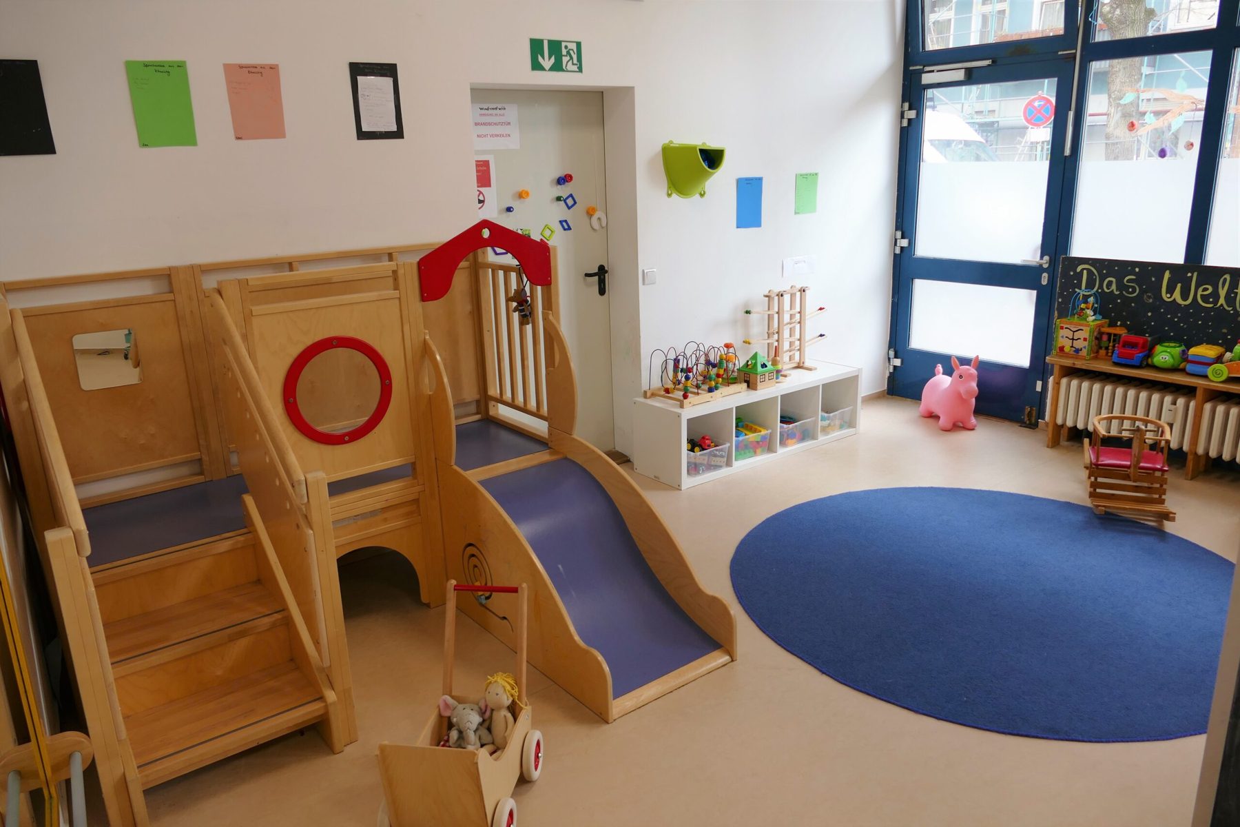 Spielraum mit Holz-Spielpodest und Rutsche